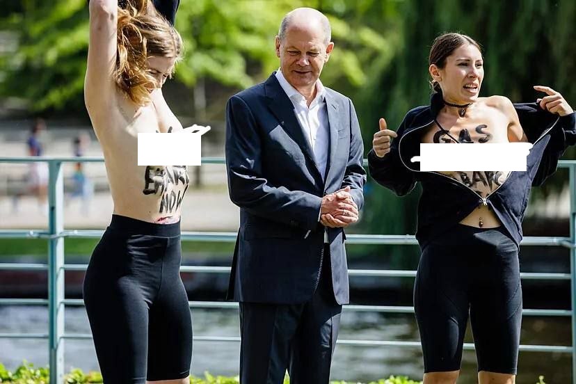 شاهد الفيديو/ مستشار ألمانيا محاط بنساء عاريات الصدر