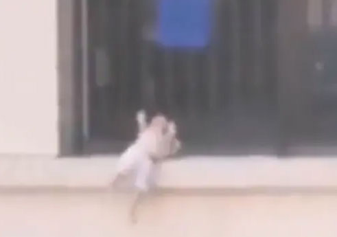 مشهد يحبس الأنفاس/ رضيع يتدلى من الطابق السابع (فيديو)