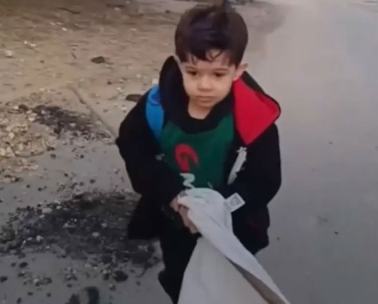 شاهد/ طفل فلسطيني يرفع الراية البيضاء هربا من القصف (فيديو)